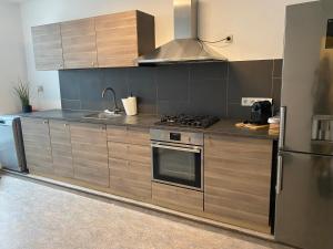 那慕尔Namur BnB的厨房配有木制橱柜和炉灶烤箱。
