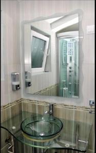 蒂瓦特Villa Mare Apartments的一间带玻璃水槽和镜子的浴室