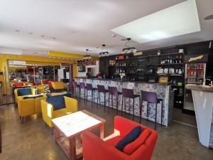 维尔纽斯Bar-celona的一间设有五颜六色椅子的餐厅和一间酒吧