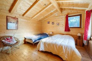 琴山朗勒堡La turra的小木屋内的卧室,配有一张床和椅子