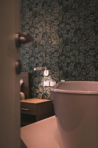 斯培西亚Affittacamere Il Portico的浴室设有粉红色的卫生间和绿色的墙壁。