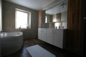 Gite L'Abeille的带浴缸、水槽和镜子的浴室