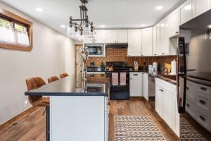比尤特Stylish Uptown Butte Condo - 632的厨房配有白色橱柜和黑色冰箱。