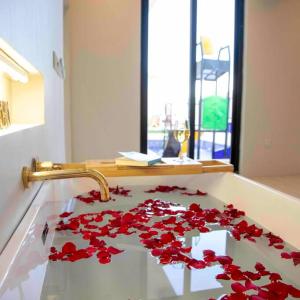 Khalij Salmanالمرفأ 2 شاليه مع مسبح والعاب مائية وغرف نوم فاخرة的浴室的盥洗盆,在柜台上摆放着红色的鲜花