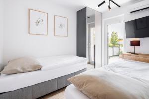 皮耶什佳尼VI&LA - Apart House的白色卧室设有两张床,配有电视