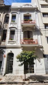 布宜诺斯艾利斯Casa Par Grand Suites的前面有棵树的白色建筑
