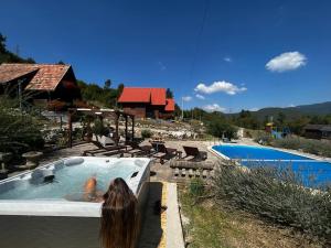 科雷尼察Holiday Park Plitvice Paradise的住在房子旁边的游泳池里的女人