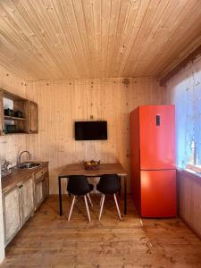 安布罗劳里Shinao Cottage的厨房配有桌子和红色冰箱