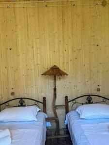 安布罗劳里Shinao Cottage的木墙客房的两张床