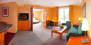 舍讷费尔德Best Western Premier Airporthotel Fontane BERlin的酒店客房带起居室