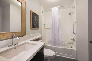 泽西市Sonesta Simply Suites Jersey City的浴室配有盥洗盆、卫生间和浴缸。