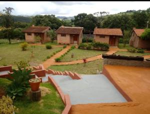 布埃诺布兰当Pousada e Camping Pé na Trilha的享有花园的景色,拥有房子的背景