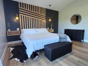 肖洛Luxurious Mountain Retreat!的一间卧室配有一张大床和一张黑色的搁脚凳