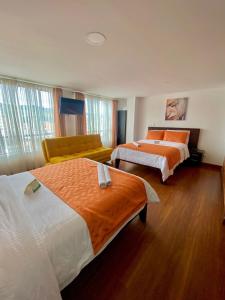 帕斯托Ayenda Hotel Posada Leon的酒店客房,设有两张床和一张沙发
