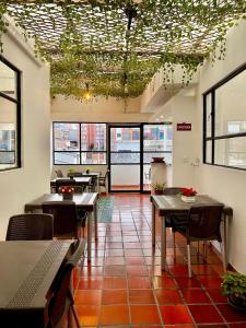 帕斯托Ayenda Hotel Posada Leon的餐厅设有桌椅和窗户。
