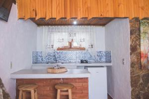蒙特韦尔迪Chales Boa Vista的厨房配有柜台和2把凳子