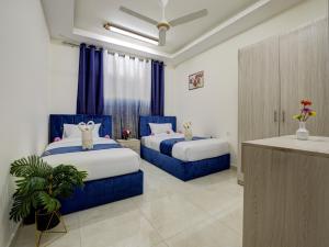 亚喀巴ENG-Murjan Apartment的蓝色和白色的客房内的两张床