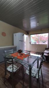 托雷斯Casa completa com 2 quartos de casal em Torres的厨房配有玻璃桌和两把椅子