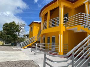 WoodsPoinciana Villas的黄色建筑的一侧设有楼梯