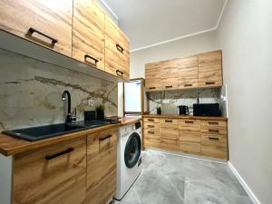 格但斯克MMRent Swamp Room的厨房配有木制橱柜和洗衣机。