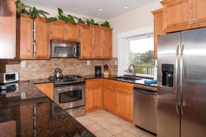 新港Michael's Beach Place @ Shoreline Ridge的厨房配有木制橱柜和不锈钢用具