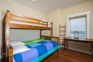 新港Michael's Beach Place @ Shoreline Ridge的一间卧室配有双层床、书桌和窗户。