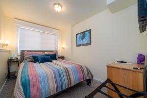 新港Nyevana Beach House的一间卧室配有一张带条纹毯子的床和窗户