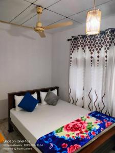 韦利格默Villa for Surf Weligama with Shisha的一间卧室配有一张带彩色毯子的床