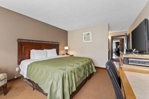Okanogan奥卡诺根品质酒店的配有一张床和一台平面电视的酒店客房