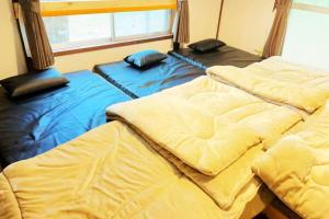 嬬恋村ガチンコBBQロッジ北軽井沢的两张睡床彼此相邻,位于一个房间里