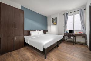 岘港Gold Time Hotel Da Nang的卧室配有一张白色大床和一张书桌