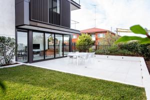 悉尼The Horizon Apartments by Urban Rest的一座房子里带白色桌椅的花园