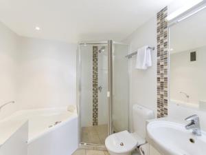 库鲁姆海滩库鲁姆卡普利斯酒店的带淋浴、卫生间和盥洗盆的白色浴室