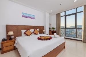 岘港星空酒店的卧室设有一张白色大床和大窗户