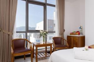 岘港星空酒店的酒店客房带一张床、一张桌子和椅子