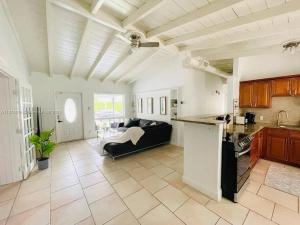 劳德代尔堡Tropical Oasis House Private Pool Family Yard的一间带黑色沙发的客厅和一间厨房