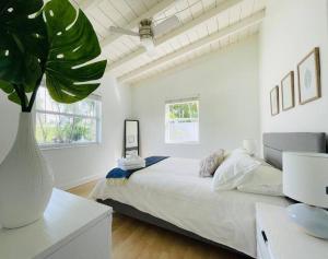 劳德代尔堡Tropical Oasis House Private Pool Family Yard的白色卧室配有大床和植物