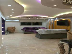 坦塔Alnahas St. Two-Bedroom Apartment With Jacuzzi的客厅配有紫色家具和天花板