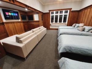陶朗加Tauranga - Big, beautiful Villa on the water!的客房设有两张床、一张沙发和一台电视。