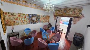 库斯科La Llave 351的一间设有蓝色和粉红色椅子和吊灯的客房