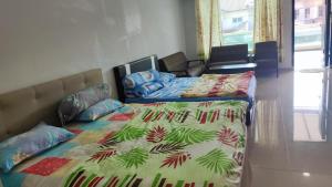 巴生BBT Double Storey Balcony Bukit Tinggi Home的一间卧室配有两张床和一张带被子的床