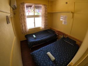 ShimajiriZamamia International Guesthouse的小型客房 - 带2张床和窗户