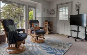 迪波湾Breeze Cottage的客厅配有2把椅子和平面电视