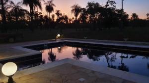 皮里韦维Residencia de Coco, Künstlerhaus in Piribebuy,的一个带灯的游泳池,享有日落美景