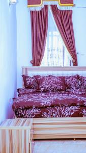 阿布贾Select Elegant 3 Rooms 3 sized king-bed @ Abuja FCT的一间卧室配有一张带红色窗帘的床和一扇窗户