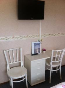 德科赫布林克兹科酒店的客房设有2把椅子和1张带笔记本电脑的书桌