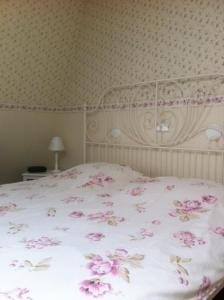 德科赫布林克兹科酒店的卧室里一张带粉红色花的床铺