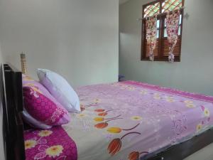 PasarbaruHomestay Melty Aprianti Tanjong Tinggi的卧室配有粉红色的床、枕头和窗户。