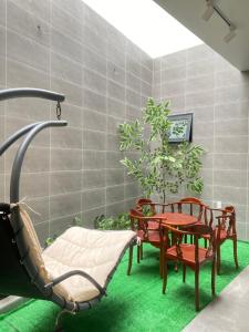 胡志明市Happy Hotel Bình Tân的一间房间,配有椅子和桌子,还有植物