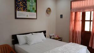 PasarbaruHomestay Suryati Tanjong Tinggi的卧室配有一张床,墙上挂着一个钟